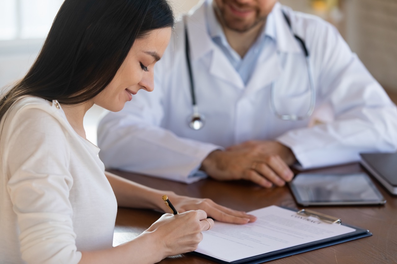 Woman filling out HIPAA form at office protected by Physicians Resource